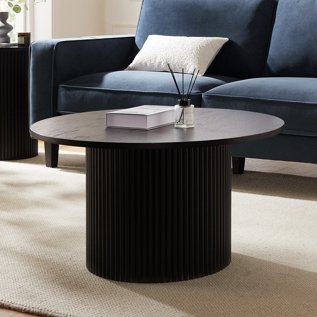 Table basse contemporaine effet bois noir avec base cylindrique à panneaux pour salon