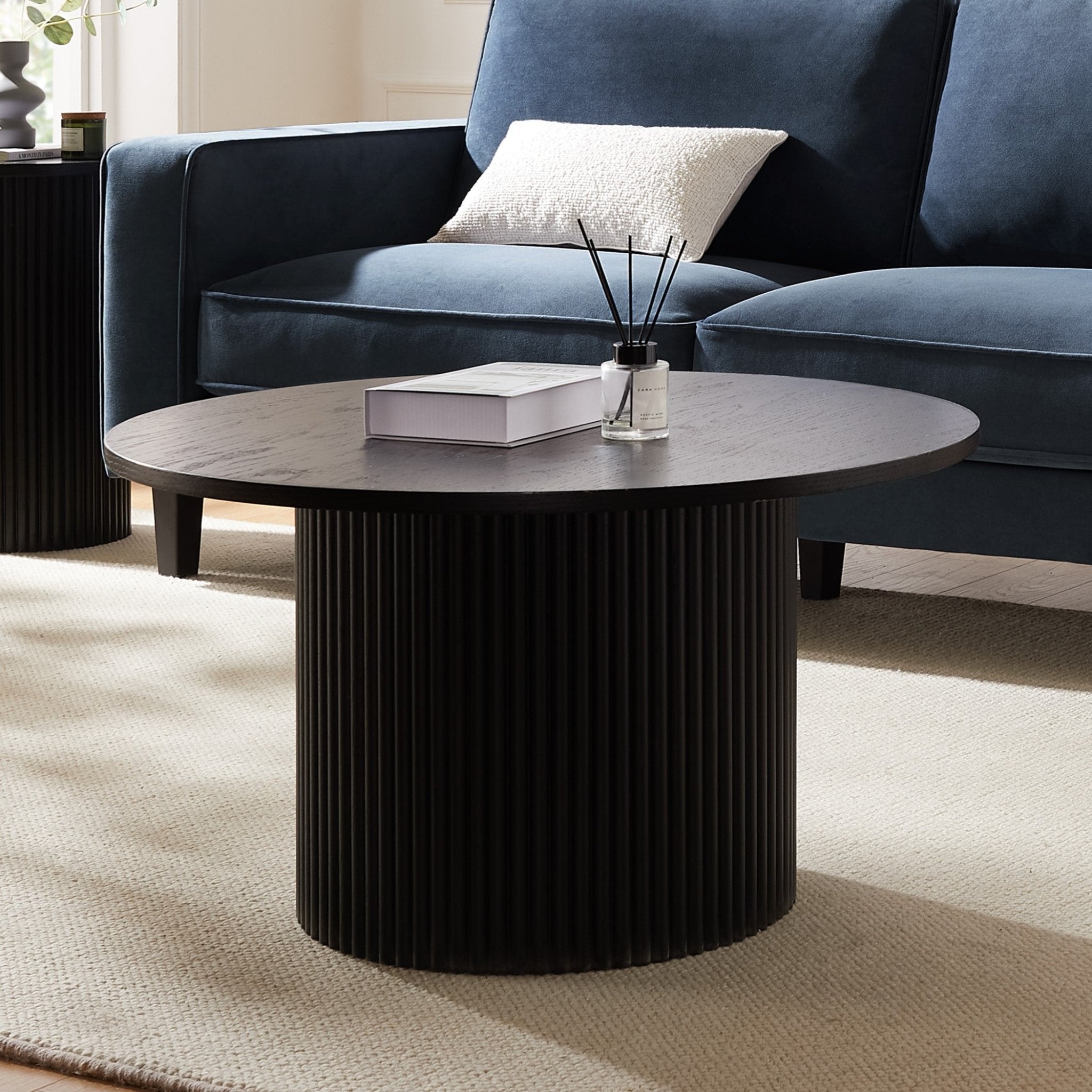 Table basse sur pied contemporaine effet bois noir avec base cylindrique fine pour le salon